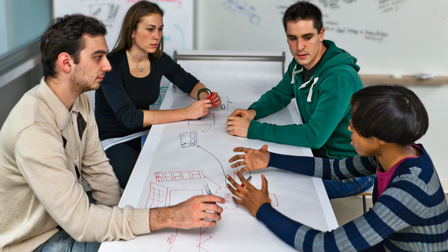A team sits around a table and plans their project