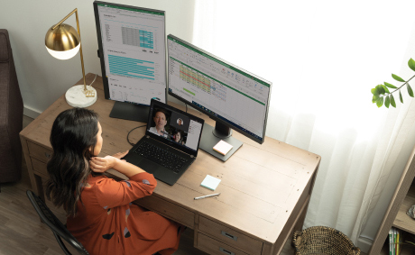 A woman having a video conference call in her laptop at her desk