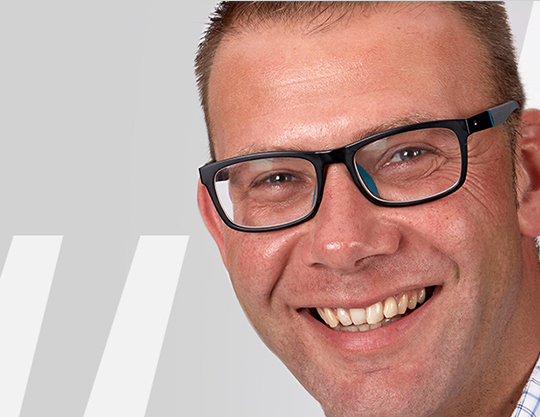 Zu sehen ist ein Mann mit Brille.