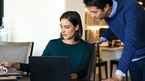 Man and woman conversing near laptop