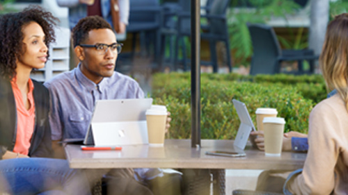People having a meeting outside with Surface tablets