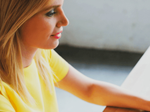 Woman smiling and working off screen