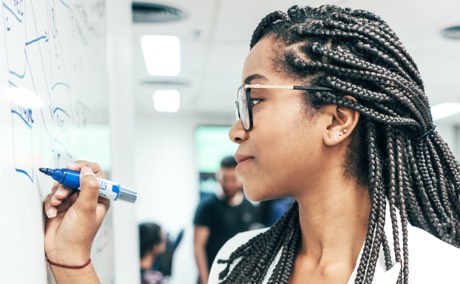 Person writing on whiteboard in office setting