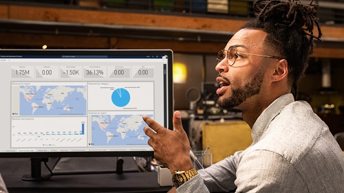 A man discussing charts displayed on his computer screen