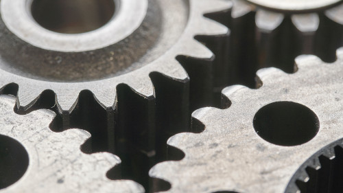 Auf diesem Bild sind silberne Zahnräder zu sehen.