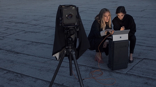 women working with camera and laptop