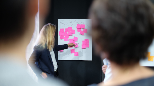 image of three people in front of a board of sticky notes