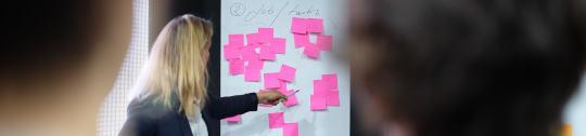 image of three people in front of a board of sticky notes