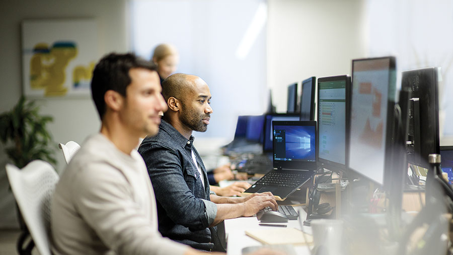 Men working on desktops