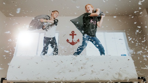 image of two children fighting playfully with pillows