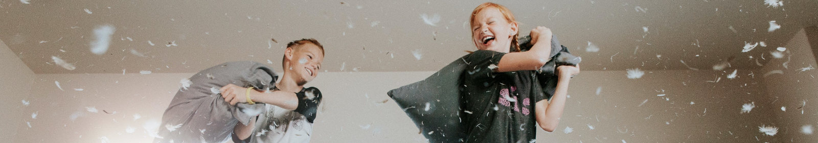 image of two children fighting playfully with pillows