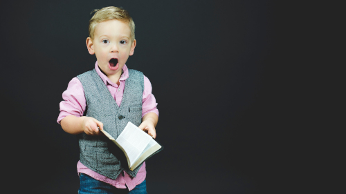 surprised child holding book
