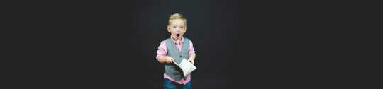 surprised child holding book