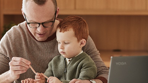 A man and his young son in front of a laptop