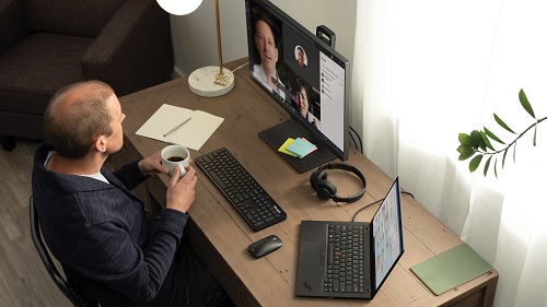 A man having a remote meeting at his desk at home