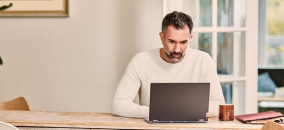 A man scrolls through a laptop computer