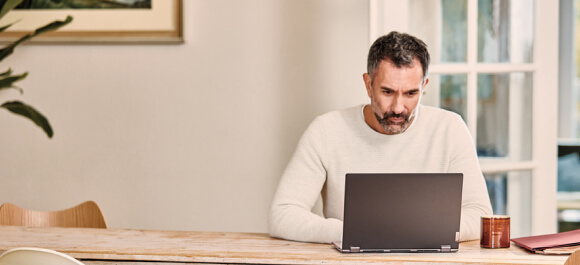 A man scrolls through a laptop computer