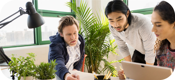 Two people having a discussion in a conference room with plants in the background