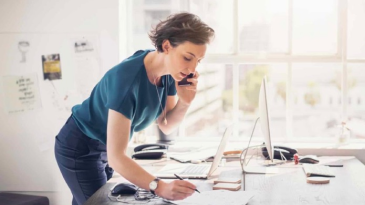 A person writing while on the phone