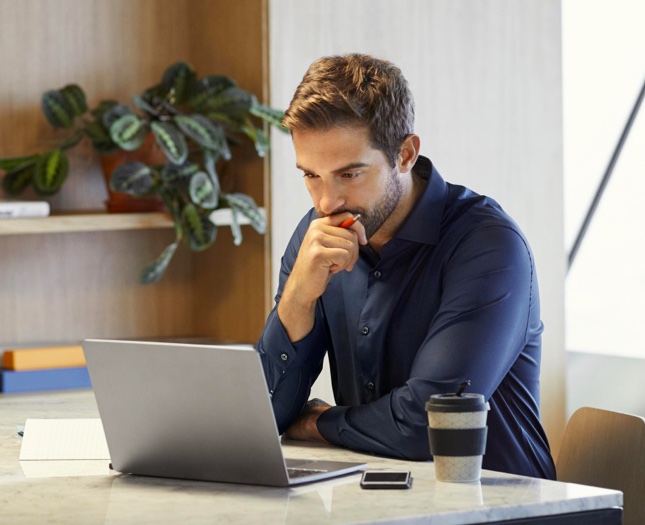 Man sitting at a table working on laptop