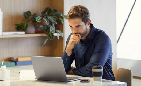 Man sitting at a table working on laptop