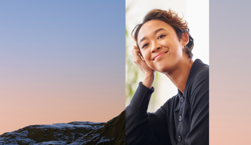 A smiling professional next to a photo of mountains