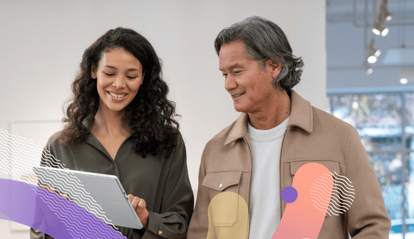 Two people smiling as they look onto a computer screen