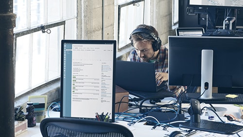 Image of a man working at desk with headphones on