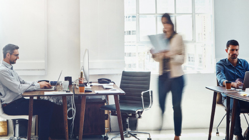 Blurred motion shot of businessman at work in a busy office