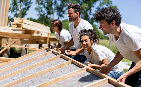 Group of volunteers building a house