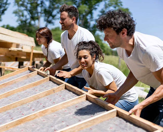 Group of volunteers building a house