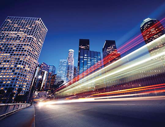 Cars drive by in a city landscape