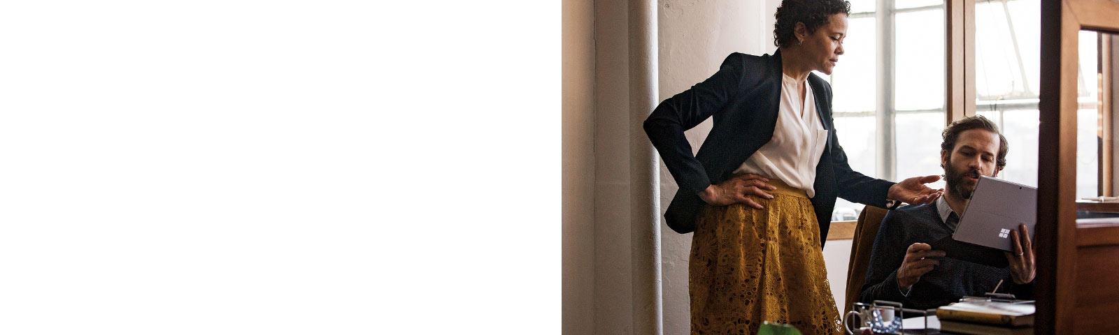 Two coworkers talking and working on Surface