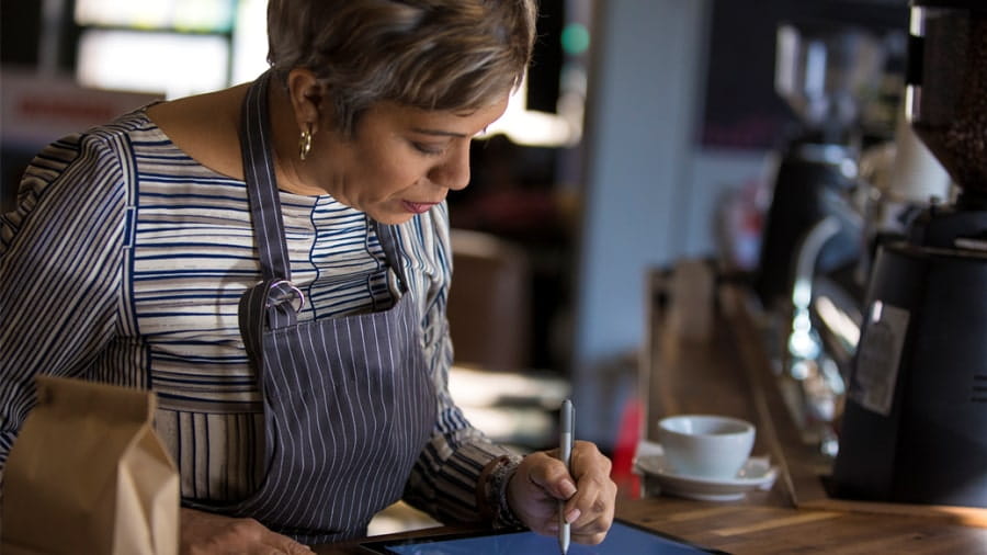 Woman working on tablet at coffeeshop