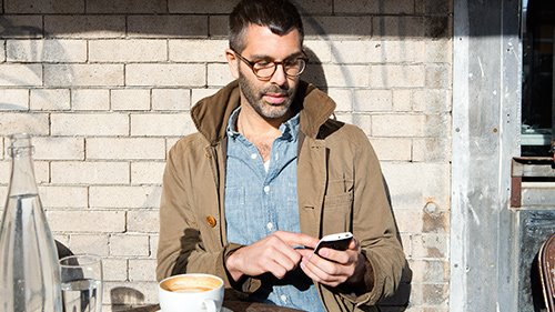 Man working on smartphone outside 