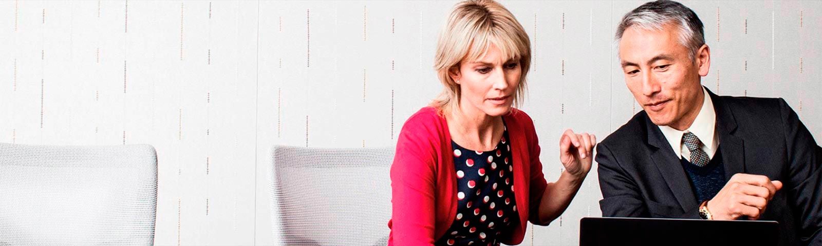 Two coworkers having a meeting working on laptop 