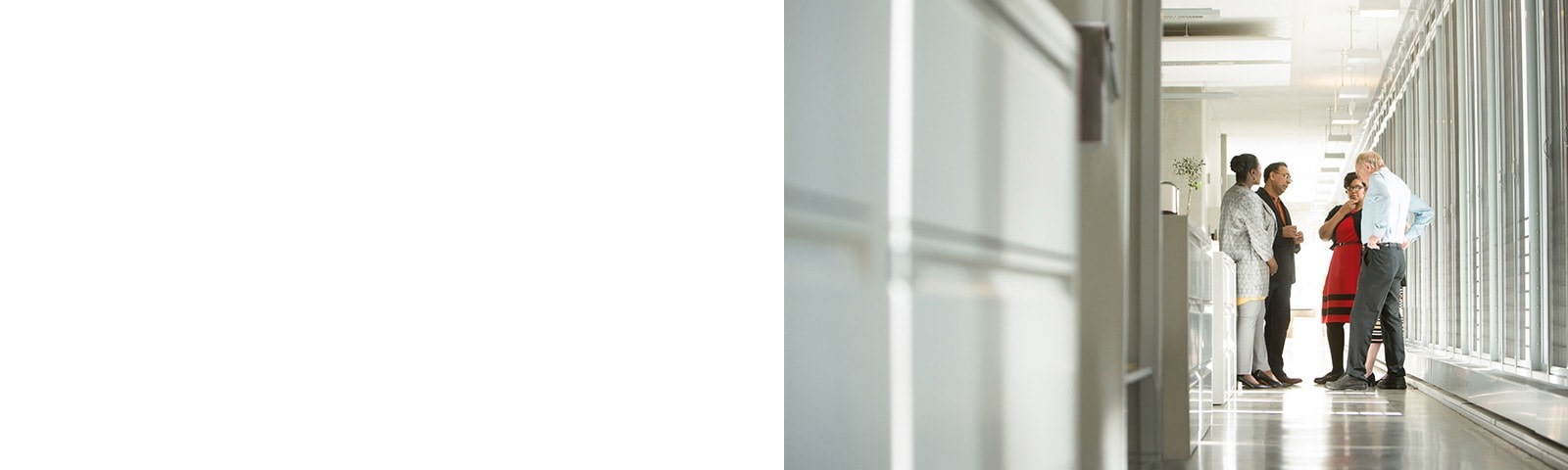 Four coworkers having a meeting in hallway 