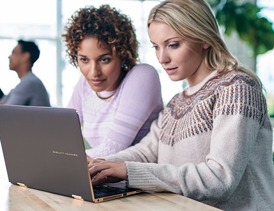 Two female colleagues working on laptop computer