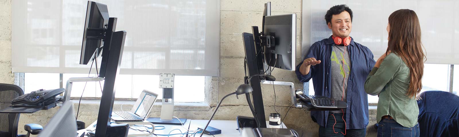 Two coworkers smiling while working near deskop 