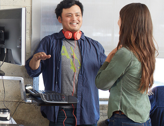 Two coworkers smiling while working near deskop 