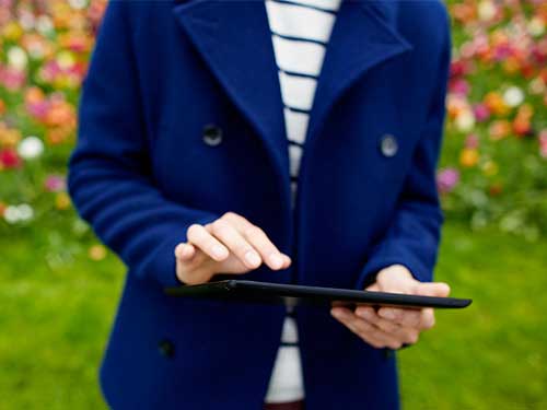Image of man working on tablet standing outside 