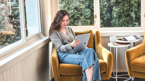 Person sitting in a chair at home using  a tablet device