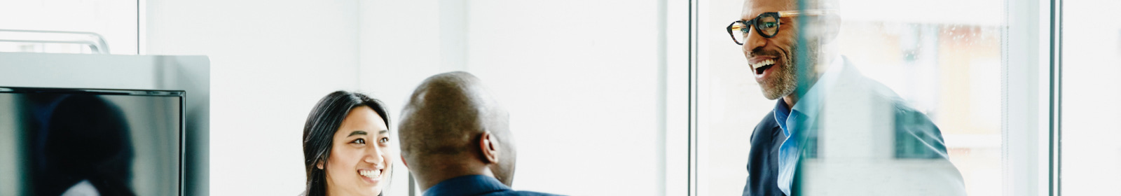 Three coworkers talking in a meeting room