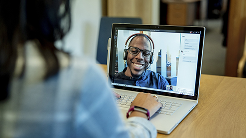 Woman facing laptop screen with man