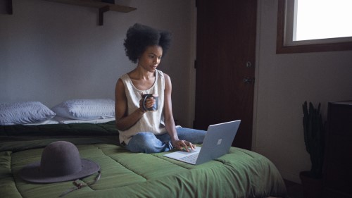 Student using Surface on bed