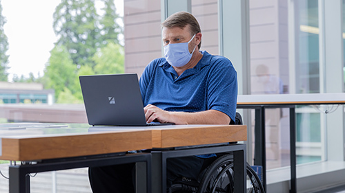 Person working with mask on Surface device