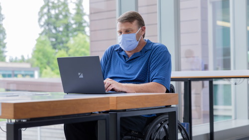 Men in a wheelchair using a laptop
