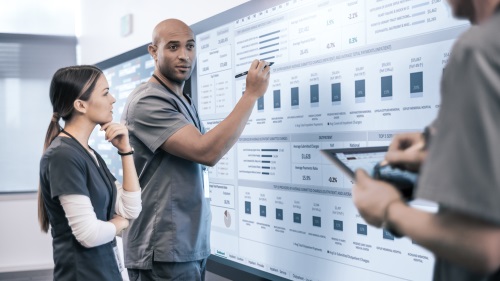 Image of a man and woman in scrubs using a Surface Hub