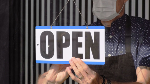 Person flipping an open sign