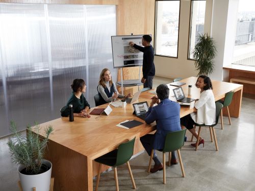 People in meeting room working with Surface Hub 2S